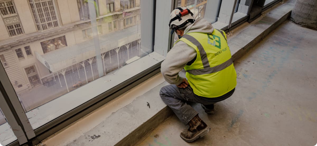 Energy Plus technician inspecting a window